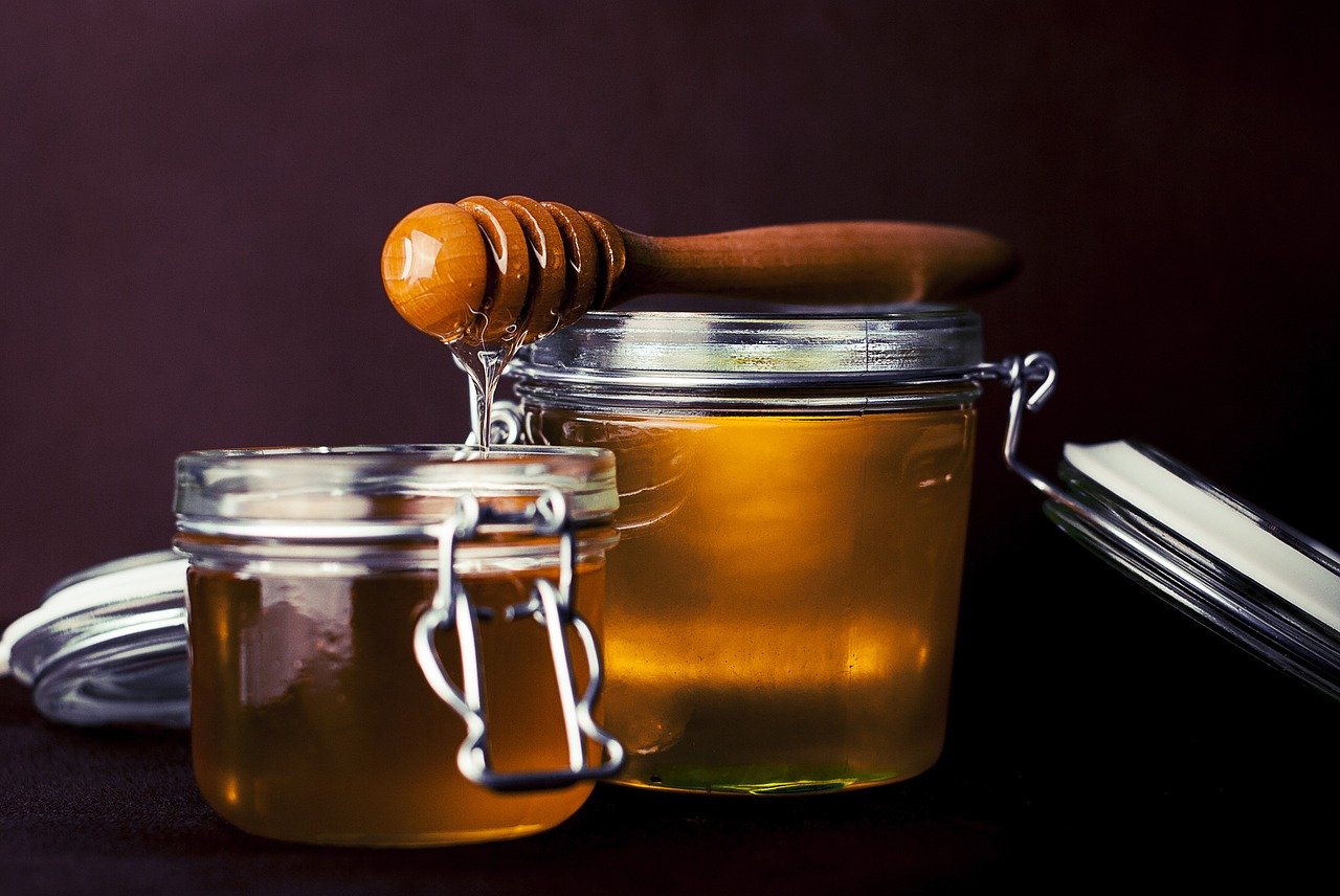 two jars of honey in a transparent container