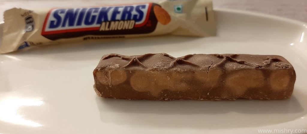 closer look at snickers almond chocolate bar on a plate