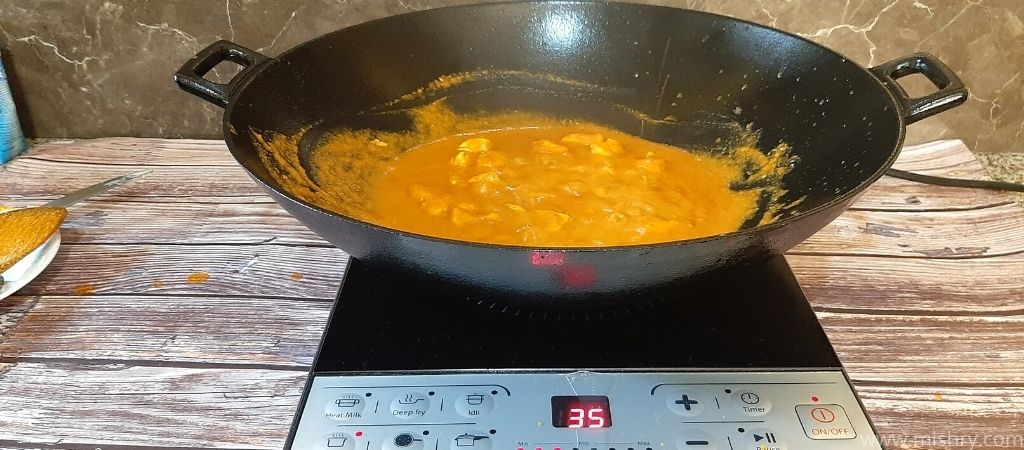 cooking gravy using butter chicken masala in a cauldron