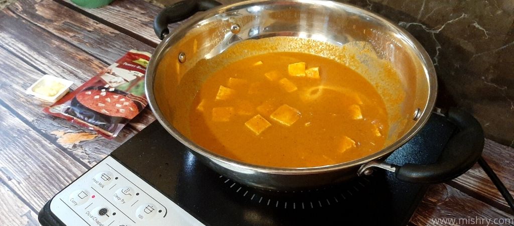 cooking gravy using paneer butter masala in a cauldron