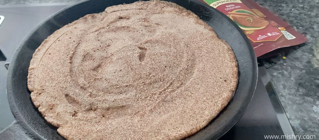 closer look at supergrain ragi dosa batter on a hot pan