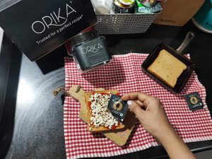 orika italian seasoning being sprinkled on bread pizza